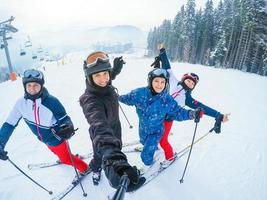 vier vrienden skiën, vrienden skiën in de bergen foto