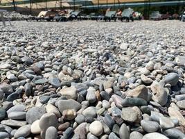 een dichtbij omhoog visie van glad gepolijst veelkleurig stenen gewassen aan wal Aan de strand. hoog kwaliteit foto