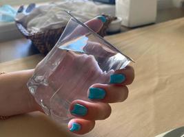 jong vrouw met een leeg water glas in haar gemanicuurd handen foto