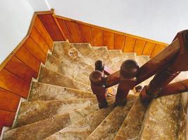 marmeren trappenhuis in de hotel. veel steil stappen, een scherp beurt Aan de trap omlaag. natuurlijk steen Aan de trap, duur materiaal, glad structuur foto