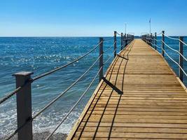 een houten lang ponton, een pier met een touw traliewerk Aan de zee Aan de strand Aan vakantie in een paradijs warm oostelijk tropisch land toevlucht foto