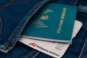 Indonesië in juli 2022. een Indonesisch paspoort en een Filippijnen luchtvaartmaatschappijen instappen voorbij gaan aan in een jeans zak. foto