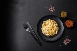 heerlijk vers pasta met pesto saus en zeevruchten Aan een zwart bord foto