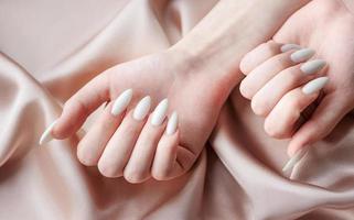 handen van een jong vrouw met wit manicure Aan nagels foto