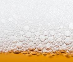 bier bubbels in een glas van vers amber bier foto