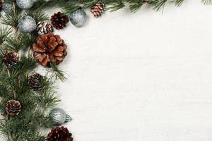 Kerstmis en nieuw jaar achtergrond met groen net takken en pijnboom kegels, wit banier, top visie, kopiëren ruimte foto