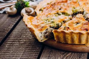 taart met champignons, kip en kruiden op de houten tafel foto