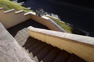 een jong vent presteert een springen door de beton borstwering. de atleet praktijken parkour, opleiding in straat conditie. de concept van sport- subculturen tussen jeugd foto