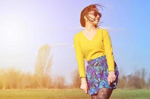 aantrekkelijk en schattig brunette meisje in een geel trui wandelingen door foto