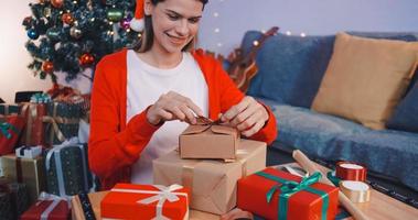 mooi jong vrouw voorbereidingen treffen presenteert voor vrienden Bij Kerstmis partij Bij huis. foto