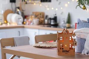 sleutel naar de huis Aan knus huis met Kerstmis decor Aan tafel van feestelijk keuken. geschenk voor nieuw jaar. gebouw, ontwerp, projecteren, in beweging naar nieuw huis, hypotheek, huur en aankoop echt landgoed foto