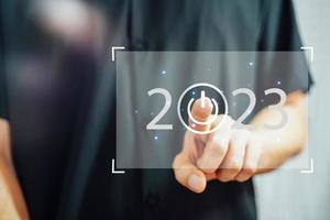 Welkom jaar 2023. nieuw jaar 2022 verandering naar 2023 concept, zakenman hand- aanraken Aan 2023 virtueel scherm. foto