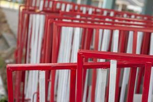 wit en rood ijzer hek voor verkeer barrière geplaatst stack veel. foto