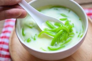 Thais toetje - Thais rijst- meel pandan blad met kokosnoot melk en siroop snoepgoed toetje Aan wit schaal, Aziatisch voedsel foto