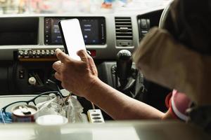 midden- oud Mens bestuurder gebruik makend van GPS navigatie Aan mobiel telefoon terwijl het rijden auto. foto