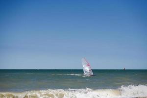 windsurfer Aan een mooi zo rijden golven Bij zee. foto