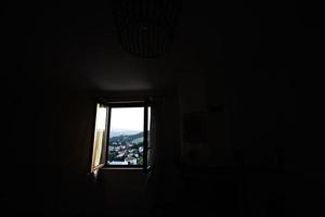 Open venster van donker kamer in zonsondergang. foto