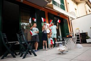 gelukkig vier kinderen met Italiaans vlaggen vieren republiek dag van Italië. foto