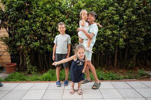vier gelukkig kinderen Aan de terras van de huis. broers en zusters. foto