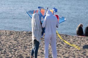 volwassenen maken een vlieger Aan een strand foto