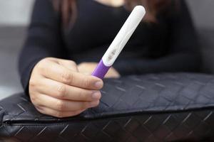 een vrouw gebruik makend van een zwangerschap uitrusting test foto