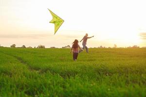 familie lanceert een vlieger in de veld- foto