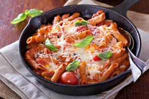 pasta bakken met penne, tomaten en mozarella foto