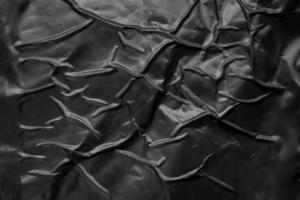 zwart verfrommeld en gevouwen plastic poster structuur achtergrond foto