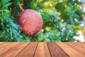 leeg hout tafel top met vervagen Kerstmis boom met bokeh licht achtergrond foto