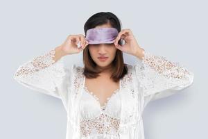 Aziatisch vrouw nemen uit een slapen masker foto