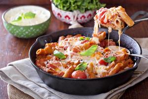 pasta bakken met penne, tomaten en mozarella foto