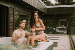 jong paar genieten van in buitenshuis heet kuip Aan vakantie foto