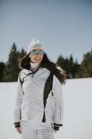 jong vrouw staand Aan de ski bijhouden foto