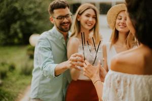 groep van gelukkig jong mensen juichen met vers limonade in de tuin foto