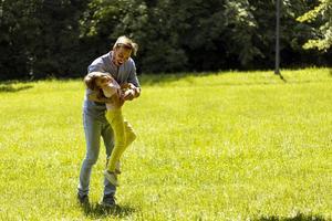 vader met dochter plezier op het gras in het park foto