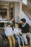 gelukkig familie met twee kinderen genieten tijd samen Aan bankstel in leven kamer foto