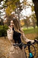 jong vrouw met elektrisch fiets in te herfst park foto