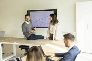 jong mensen uit het bedrijfsleven presenteren project strategie tonen ideeën Aan interactief whiteboard in kantoor foto