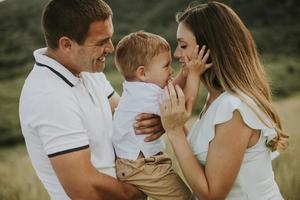 jong gezin met schattige kleine jongen die plezier heeft buiten in het veld foto