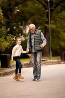 opa uitgeven tijd met zijn kleindochter in park Aan herfst dag foto