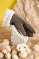 handschoenen en champignons Aan een geel achtergrond, veganistisch leer concept foto