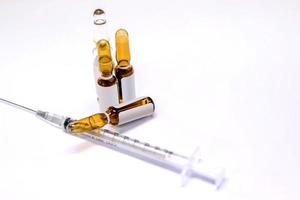 3 ml. bruin ampullen van drug en plastic injectiespuit Aan wit achtergrond. foto