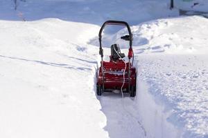 schoonmaak de pad van de sneeuw met een sneeuwploeg Aan een winter dag foto