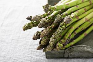 bundel van groen asperges Aan een dienblad foto