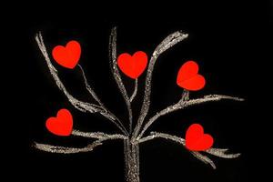 krijt tekening boom Aan een zwart schoolbord met rood harten Aan een boom foto