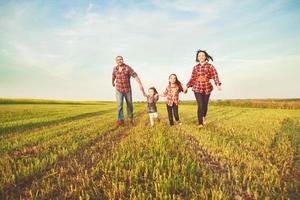 familie rennen samen in de veld- foto