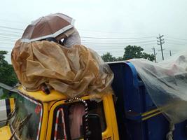 mensen krijgen in trein dak naar Gaan naar hun huis districten Aan een bezig weg eid reis van arm mensen in Bangladesh wie zijn op reis in de regenachtig tijd in Bangladesh gedurende de eid seizoen foto