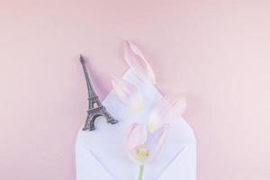 roze tulp in envelop met eiffel toren miniatuur foto