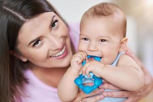 moeder en haar pasgeboren baby met tandjes krijgen ring foto