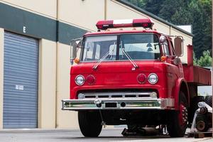 oud rood ontmanteld brand motor geparkeerd in een industrieel complex foto